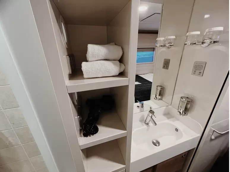 (Ví dụ về kệ để đồ trong phòng tắm và khu vực bồn rửa bên trong Studio Staterooms, hoàn chỉnh với máy sấy tóc)
